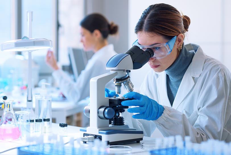 woman scientist looking into a microscope