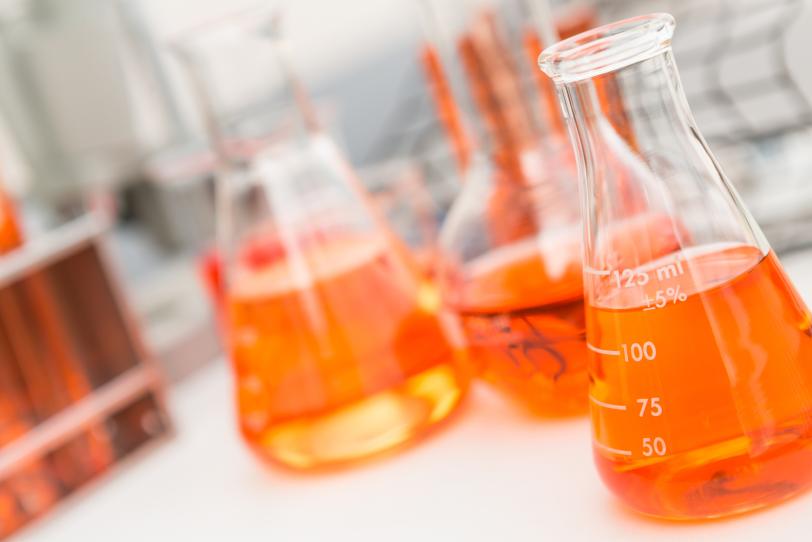 beakers in lab full of orange liquid
