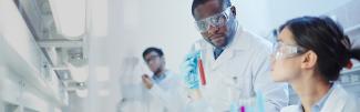 Mand and woman scientists in lab looking at test tube